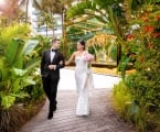 Bride & groom walking away from a mammoth skeleton encased in class