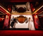 bride and groom stand on either side of Faena Theater sign